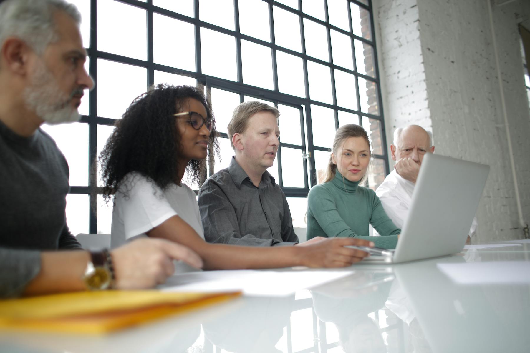 Business team collaborating around a laptop in a modern office